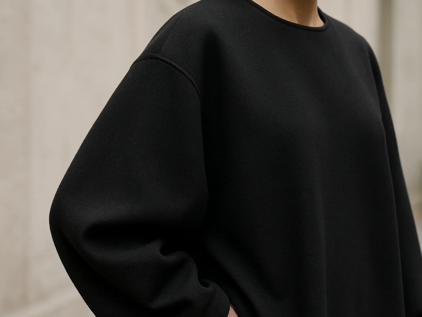 Close editorial detail of a black oversized garment on a model, s